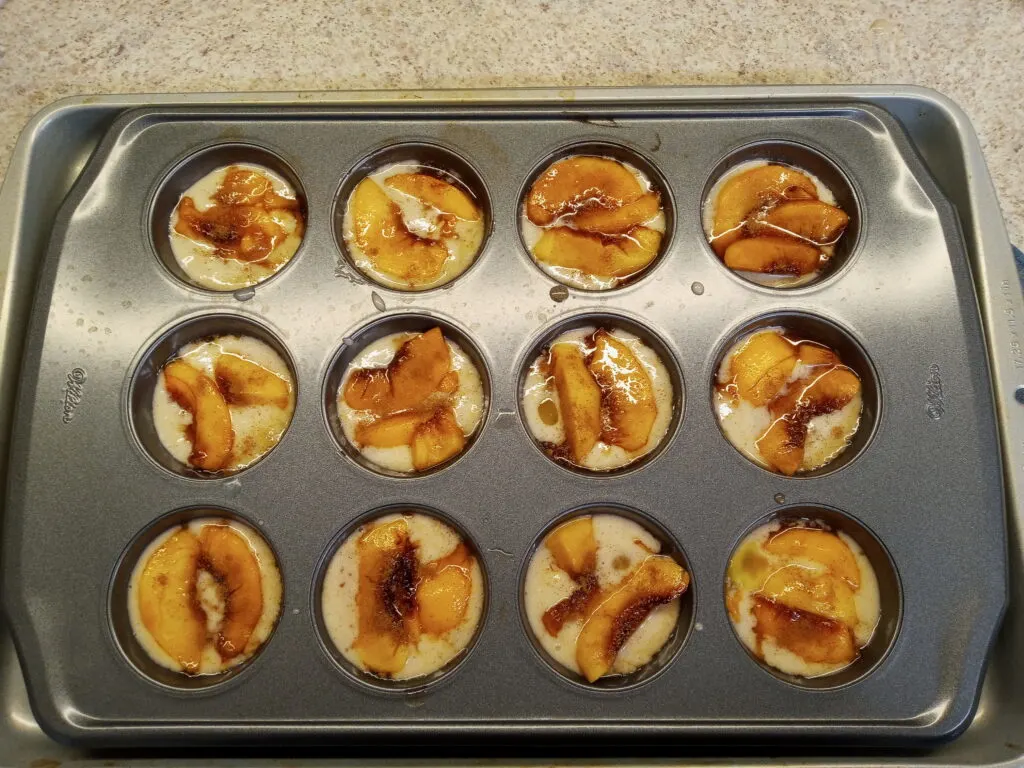 Easy peach cobbler ready for cooking in muffin pan